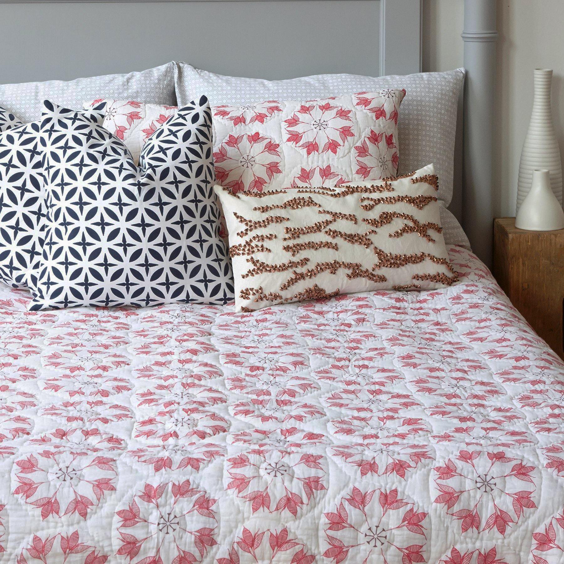 Adelina Quilt by Allem Studio - Round floral pattern of pink and merlot colour on one side. The reverse print has a geometric pattern in a contrast merlot colour. 