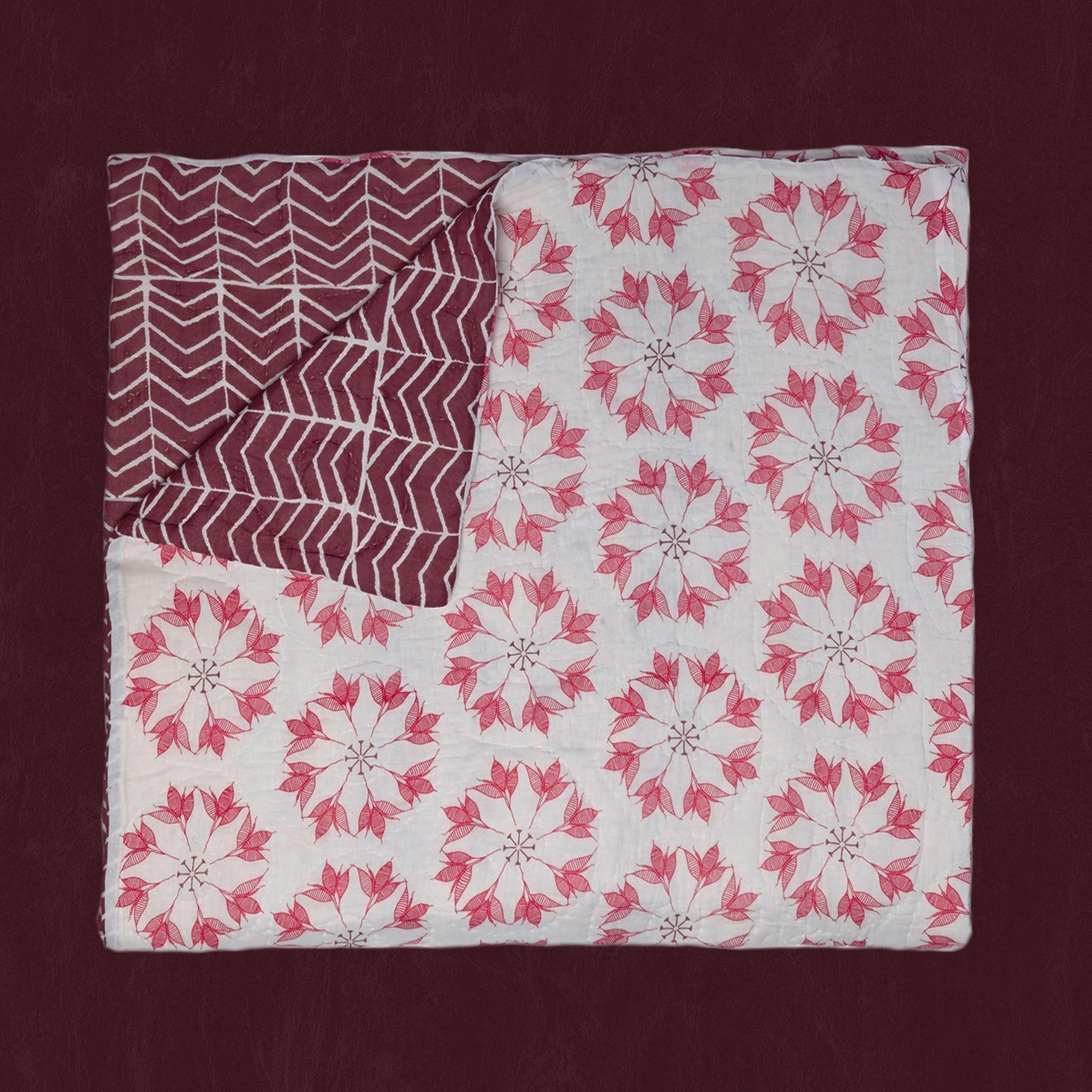 Adelina Quilt by Allem Studio - Round floral pattern of pink and merlot colour on one side. The reverse print has a geometric pattern in a contrast merlot colour. 