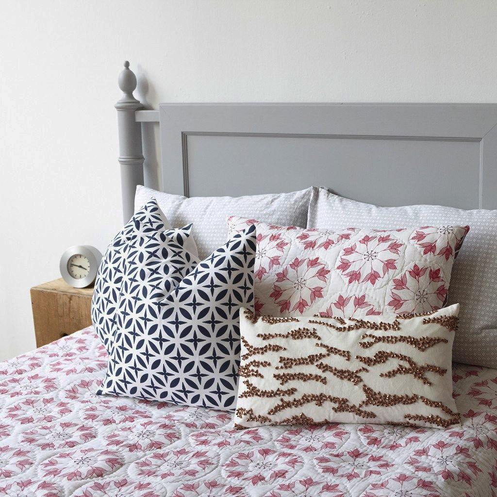 Adelina Quilt by Allem Studio - Round floral pattern of pink and merlot colour on one side. The reverse print has a geometric pattern in a contrast merlot colour. 