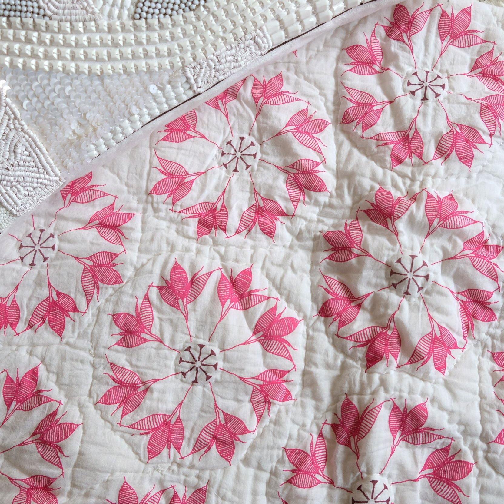 Adelina Quilt by Allem Studio - Round floral pattern of pink and merlot colour on one side. The reverse print has a geometric pattern in a contrast merlot colour. 